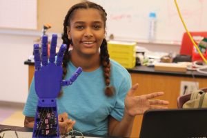 Student showing robotic blue hand project.
